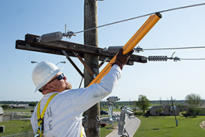 Inmate in bucket truck lifting an electrical line